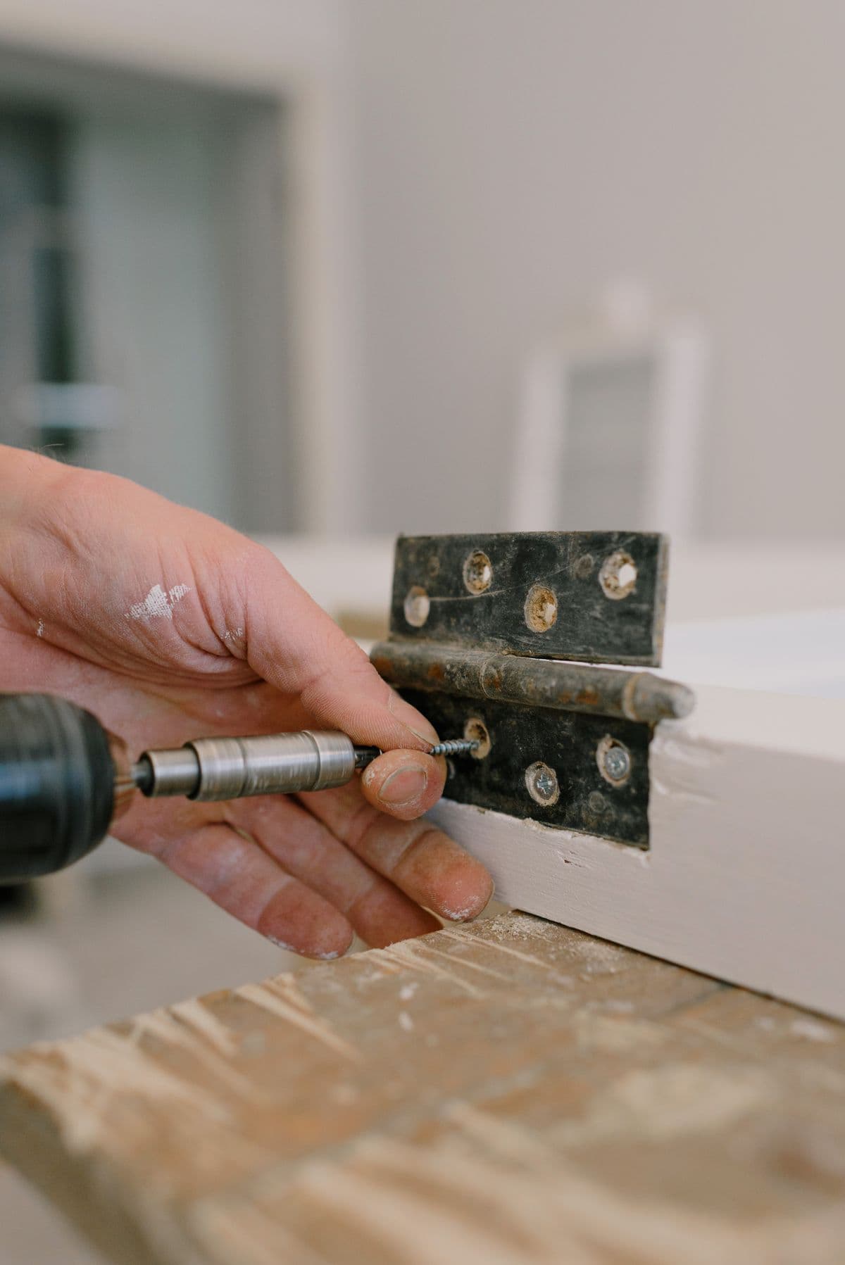 Skilled hands repairing a door hinge