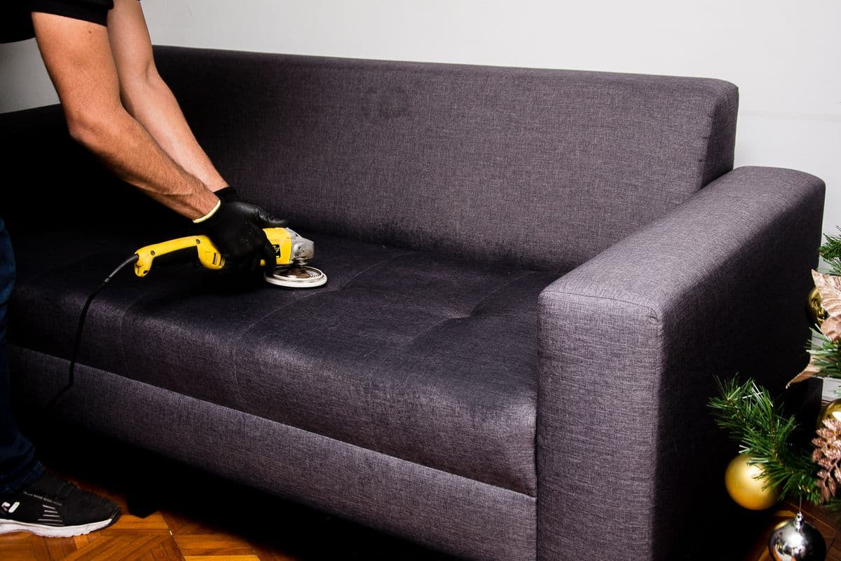 A professional carefully restoring a sofa